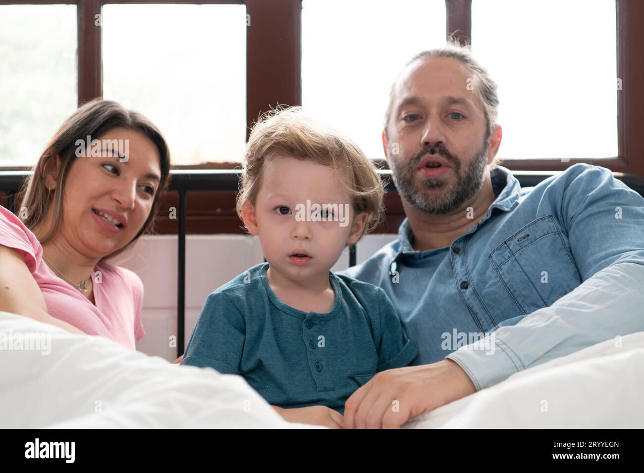 Dopo che il bambino si sveglia dal pisolino, suo padre e sua madre si impegnano in attività piacevoli nella sua camera da letto. Foto Stock