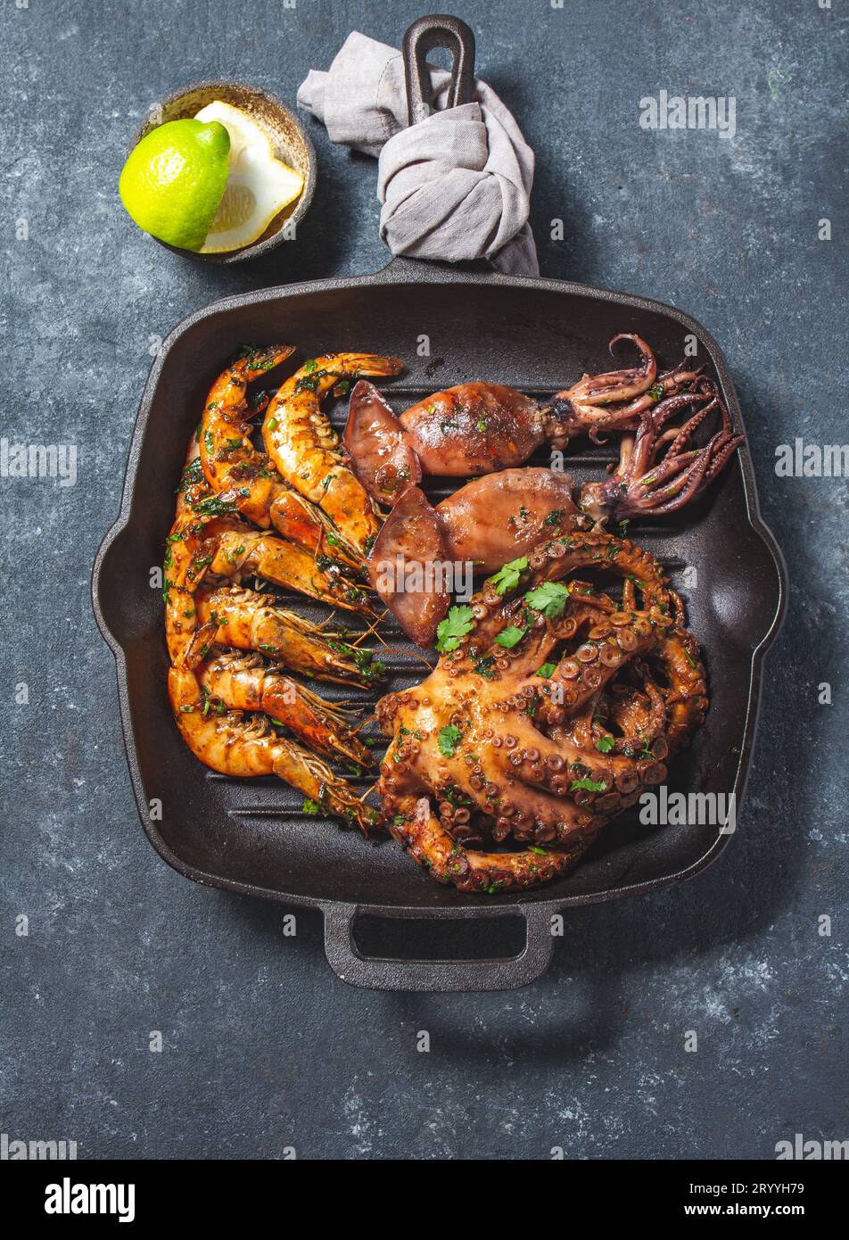 Pannocchie, calamari e polpo grigliati in una padella in ghisa Foto Stock
