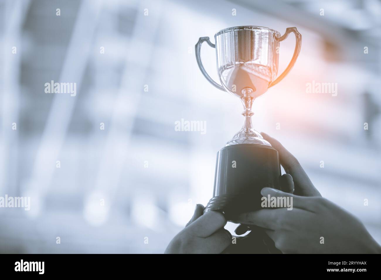 Trofeo d'argento con sfondo urbano. Concetto di successo e raggiungimento dei risultati. Tema sport e coppa premio. Foto Stock