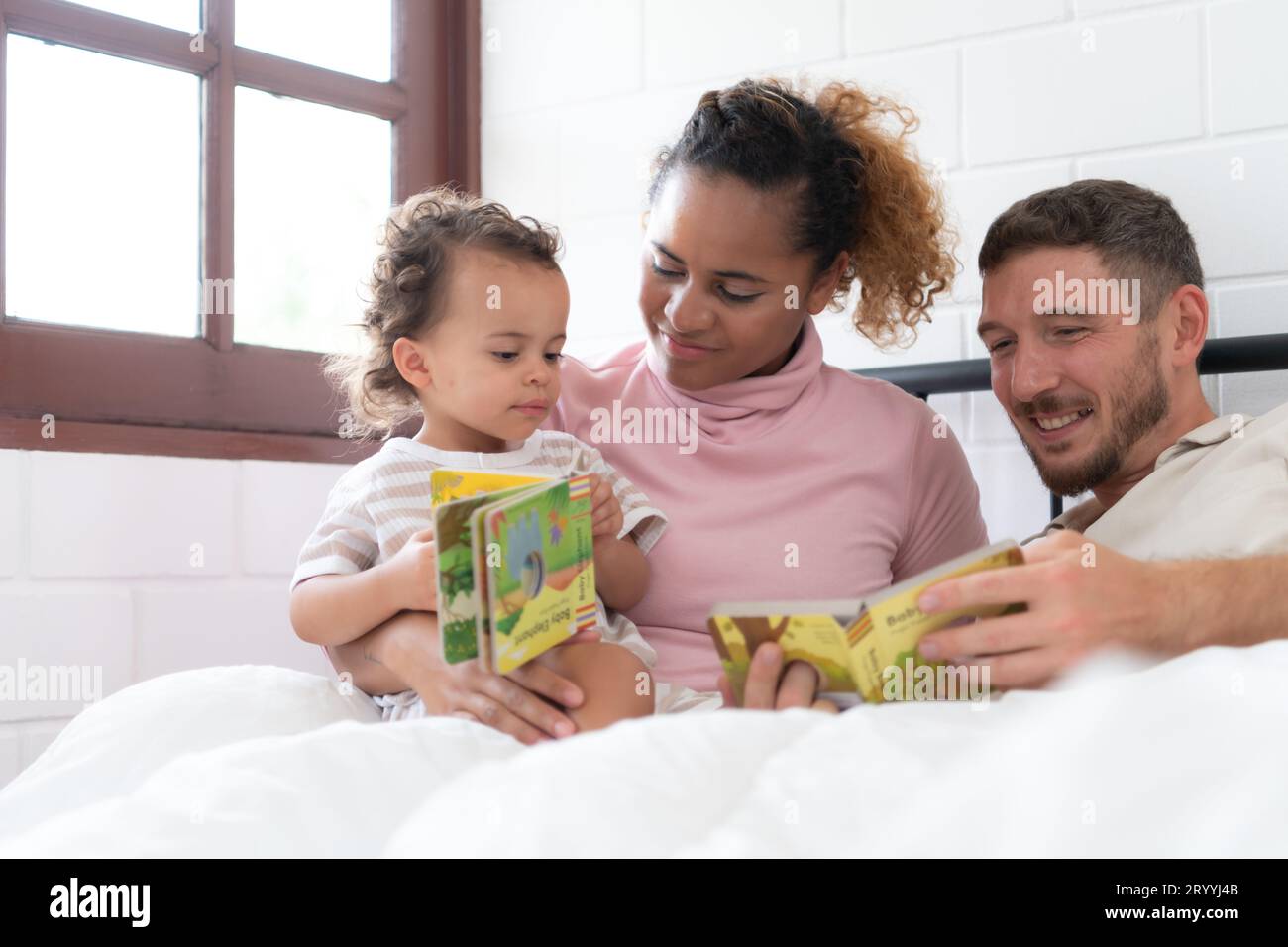 Il padre della bambina legge storie ai bambini prima di andare a letto per rilassarsi e dormire sonni tranquilli fino alla mattina. Foto Stock