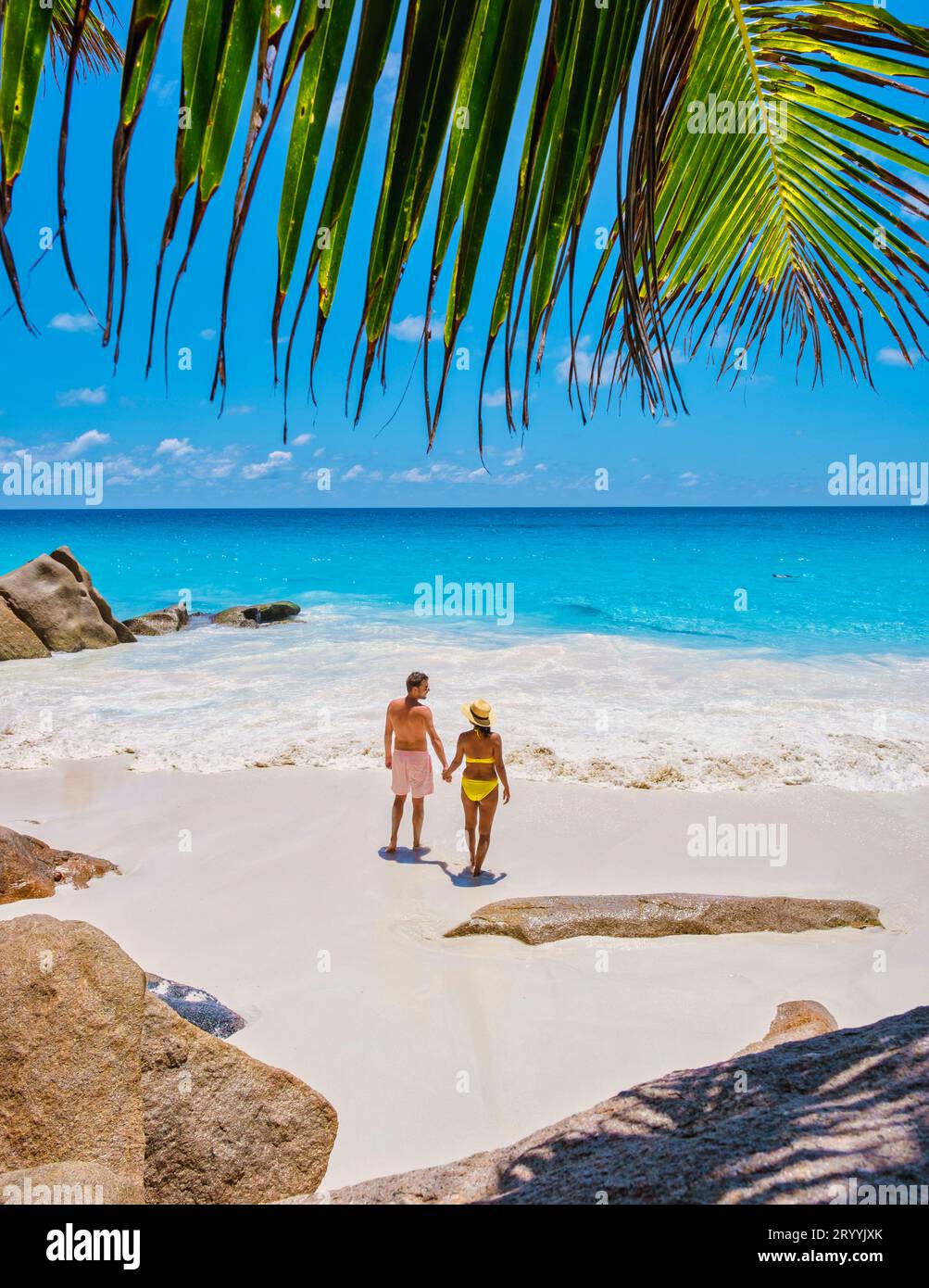 Anse Georgette Praslin Seychelles, giovane coppia di uomini e donne su una spiaggia tropicale durante una vacanza di lusso alle Seychelles. TR Foto Stock
