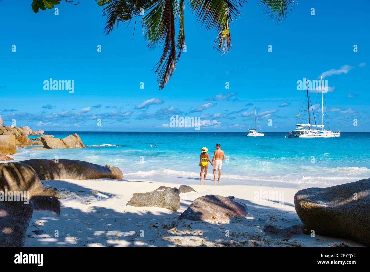 Anse Georgette Praslin Seychelles, giovane coppia di uomini e donne su una spiaggia tropicale durante una vacanza di lusso alle Seychelles. TR Foto Stock