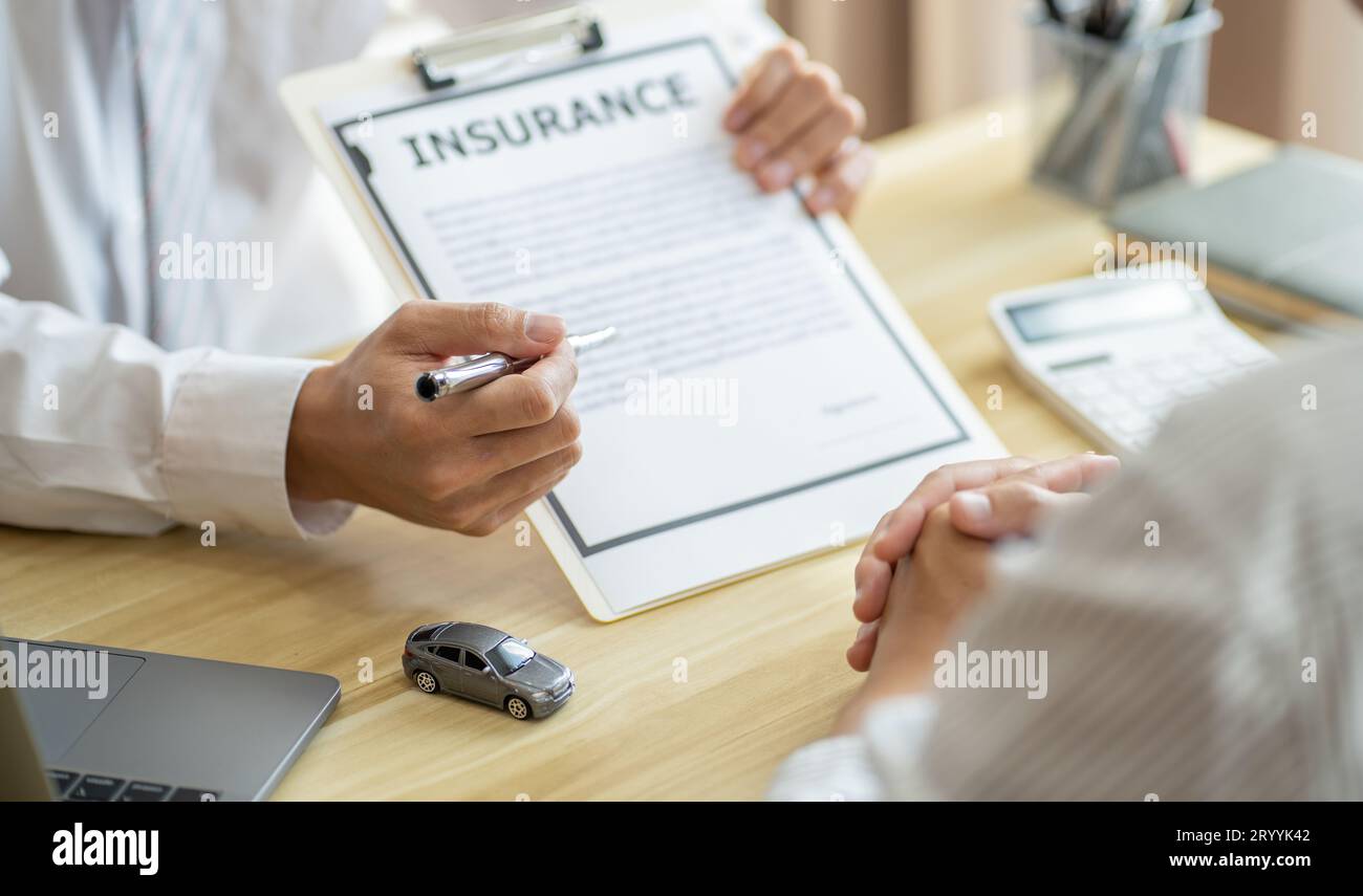 Agente assicurativo del registro delle perdite che ispeziona la vettura danneggiata. Il responsabile delle vendite fornisce un documento del modulo di richiesta di consulenza che prende in considerazione il morgag Foto Stock