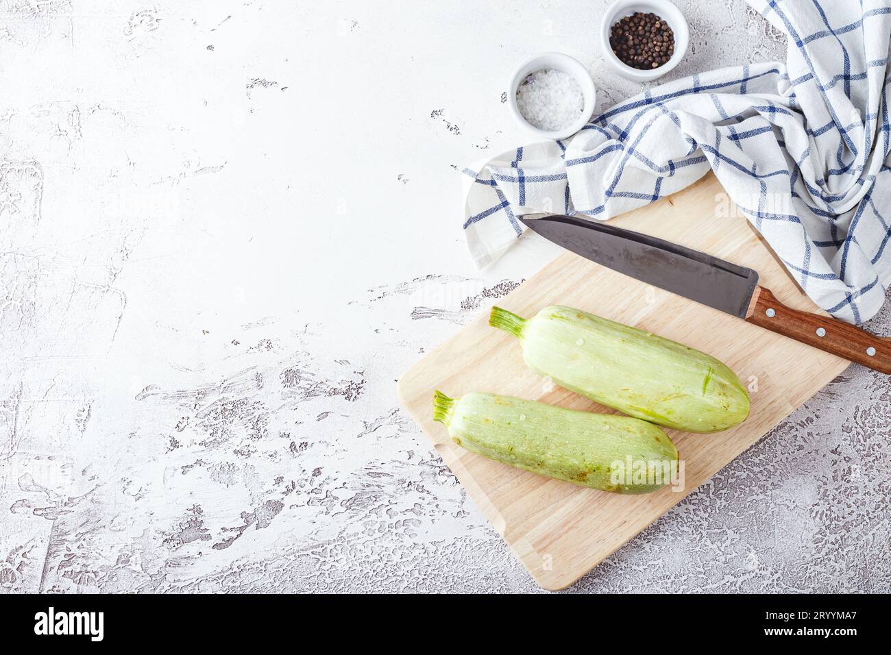 Zucchine fresche su una tavola di legno con un coltello Foto Stock