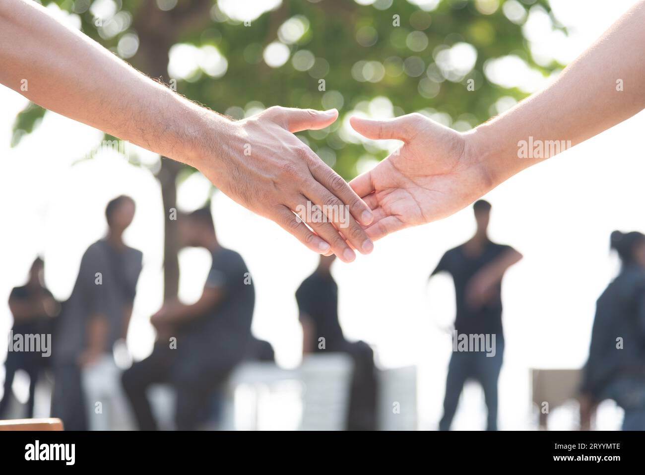 Chiuso di agitare a mano con persone di background. La cooperazione commerciale e il concetto di unità. Business e all'esterno del tema. Foto Stock