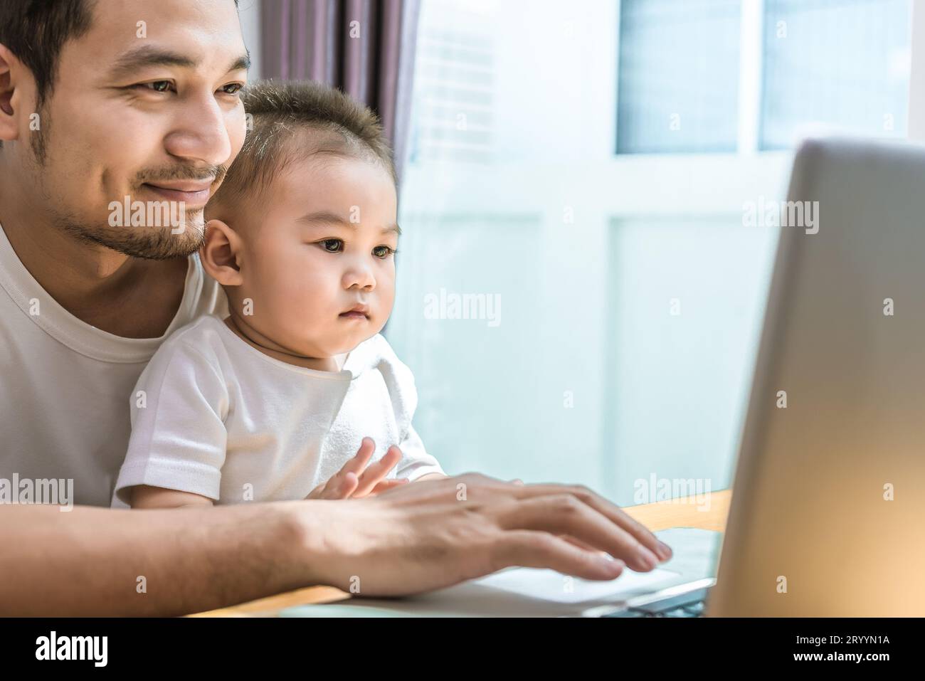 Solo papà e figlio utilizzando laptop insieme felicemente. Tecnologia e stili di vita del concetto. La famiglia felice e baby tema. Foto Stock