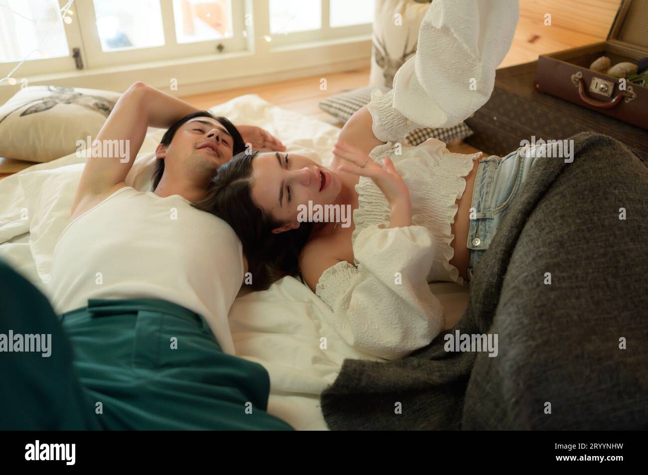 Giovane coppia in soffitta la mattina, salutare gli amici online utilizzando lo smartphone. Foto Stock