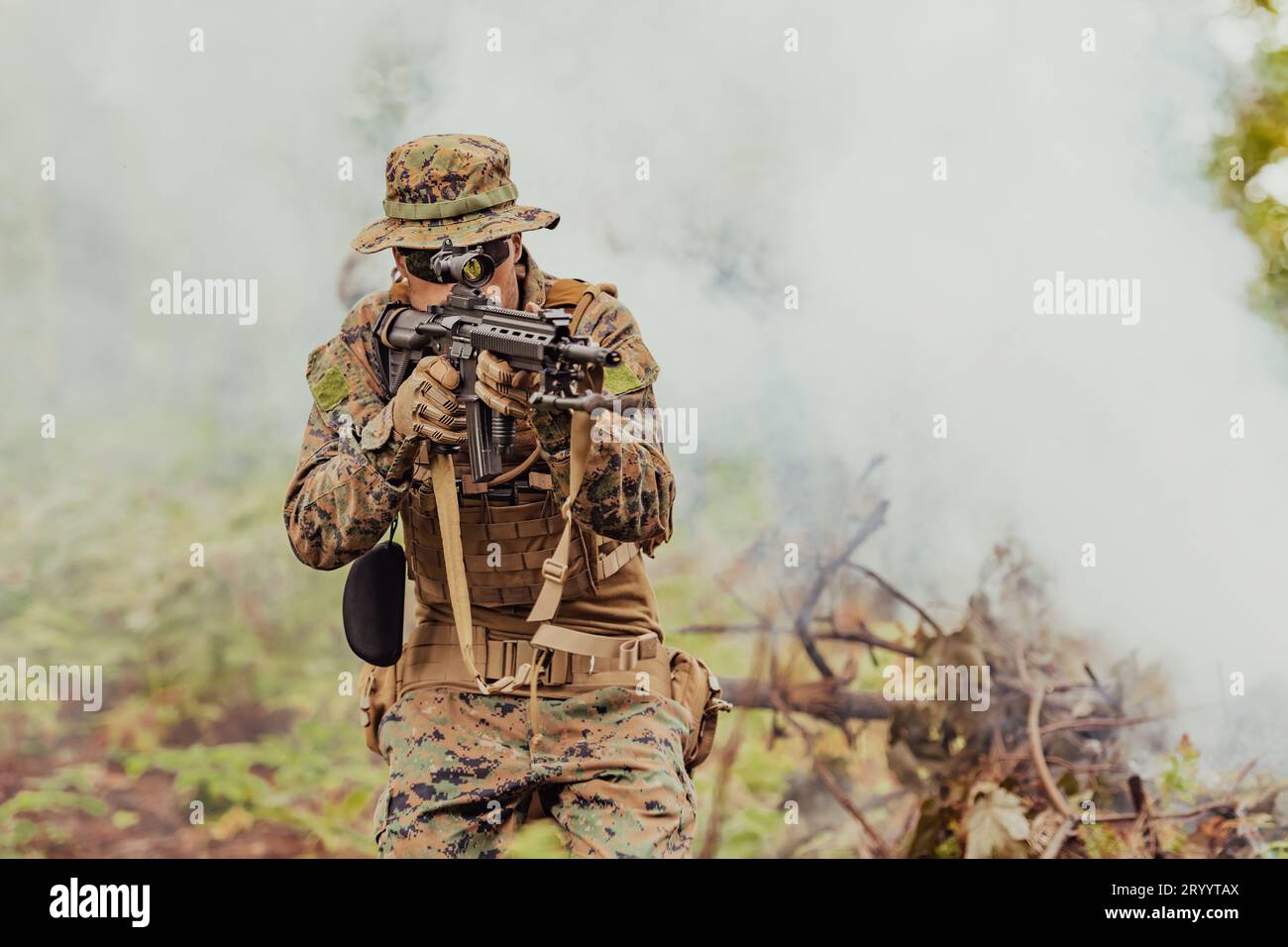 Un soldato combatte in una zona di foresta di guerra circondata da un incendio Foto Stock