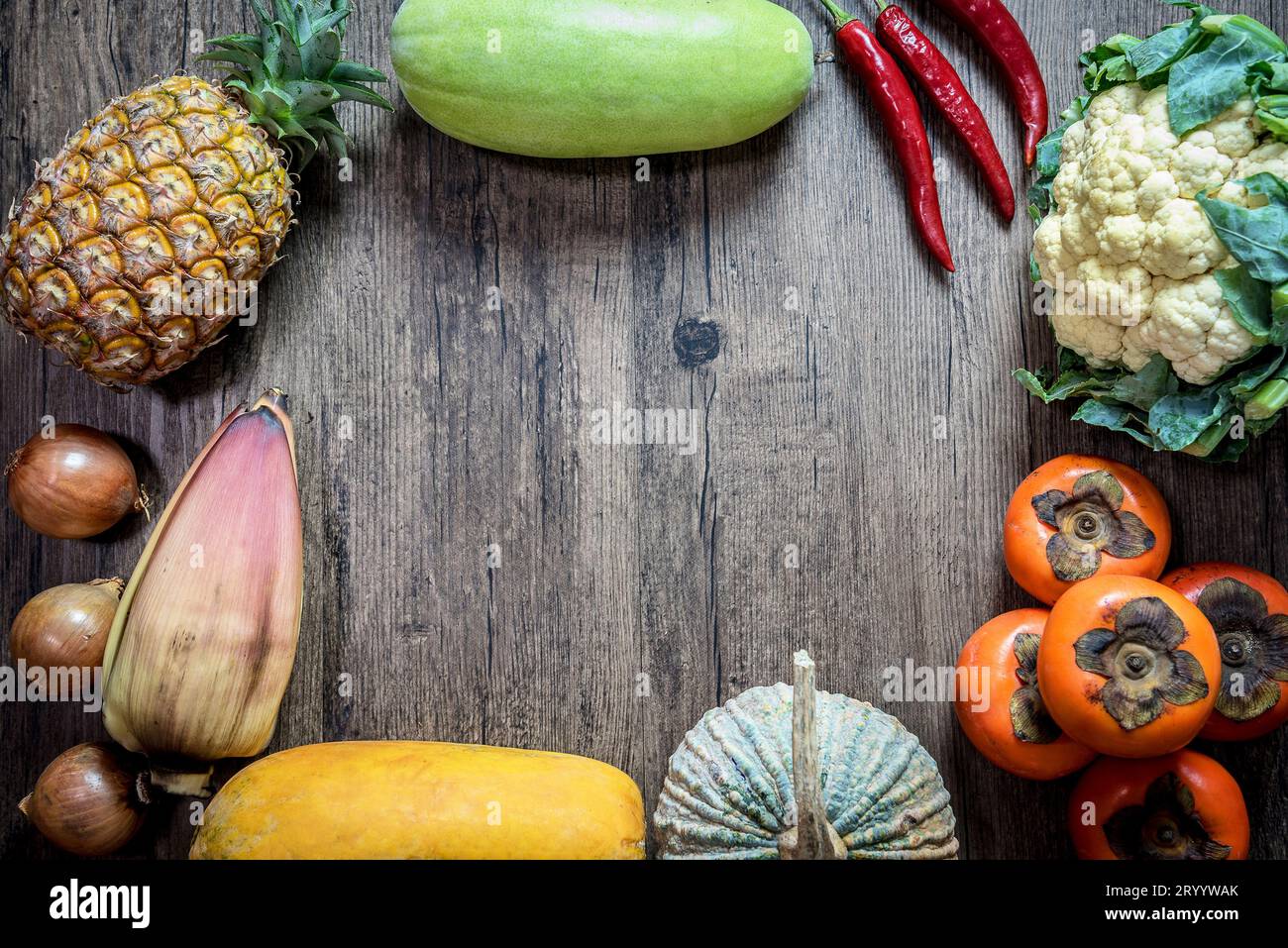 Frutta e verdura asiatica, organica e naturale, priva di sostanze chimiche (ananas, zucca e peperoncino, ecc.), esposte su backgroun in legno Foto Stock