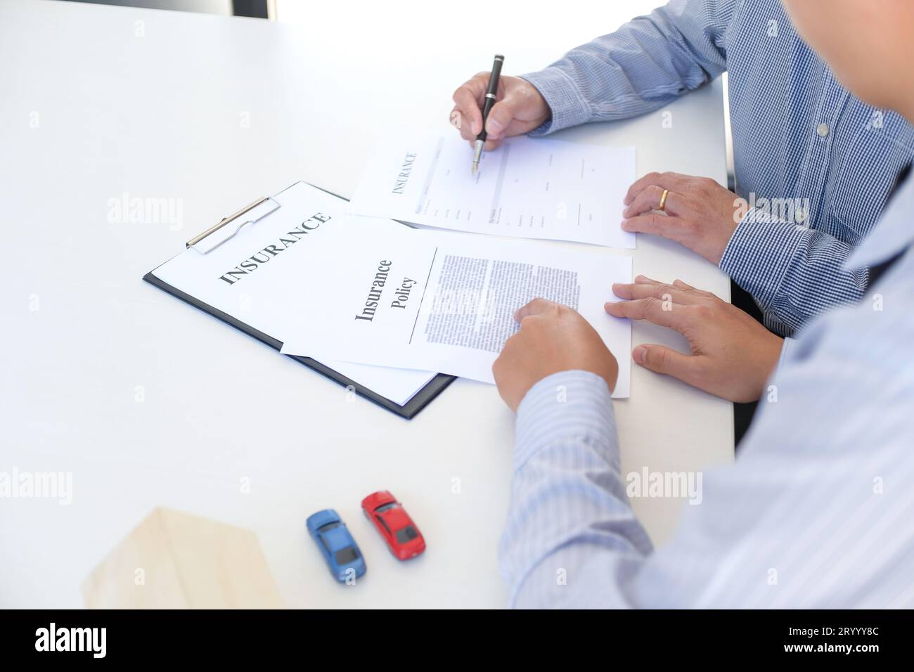 Responsabile delle vendite che dà il documento di modulo di richiesta di consiglio, considerando l'offerta di prestito ipotecario per l'assicurazione dell'automobile e della casa. Foto Stock