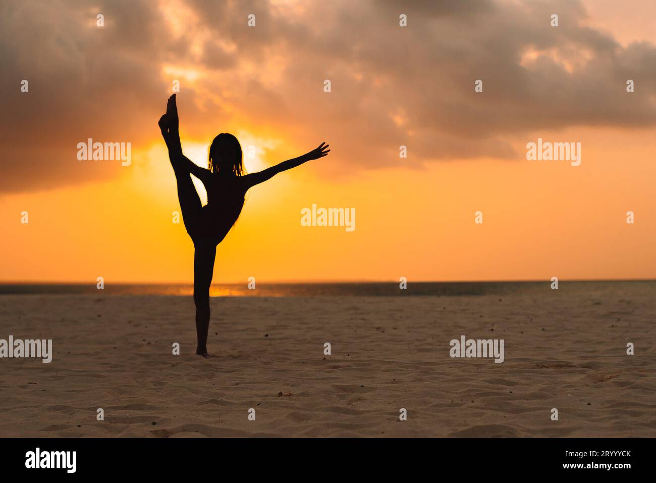 Felice adorabile bambina sulla spiaggia bianca al tramonto. Foto Stock