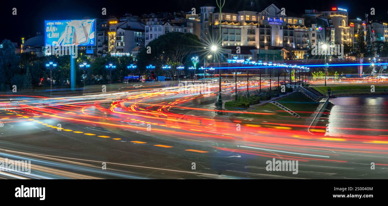 Scena notturna della città di da Lat, Vietnam illuminata dai fari delle auto di passaggio in una notte buia per aiutare il traffico a fluire più agevolmente quando i turisti Foto Stock