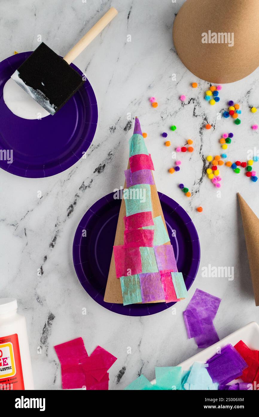 Cono di carta velina parzialmente decorata con colla e materiali Foto Stock