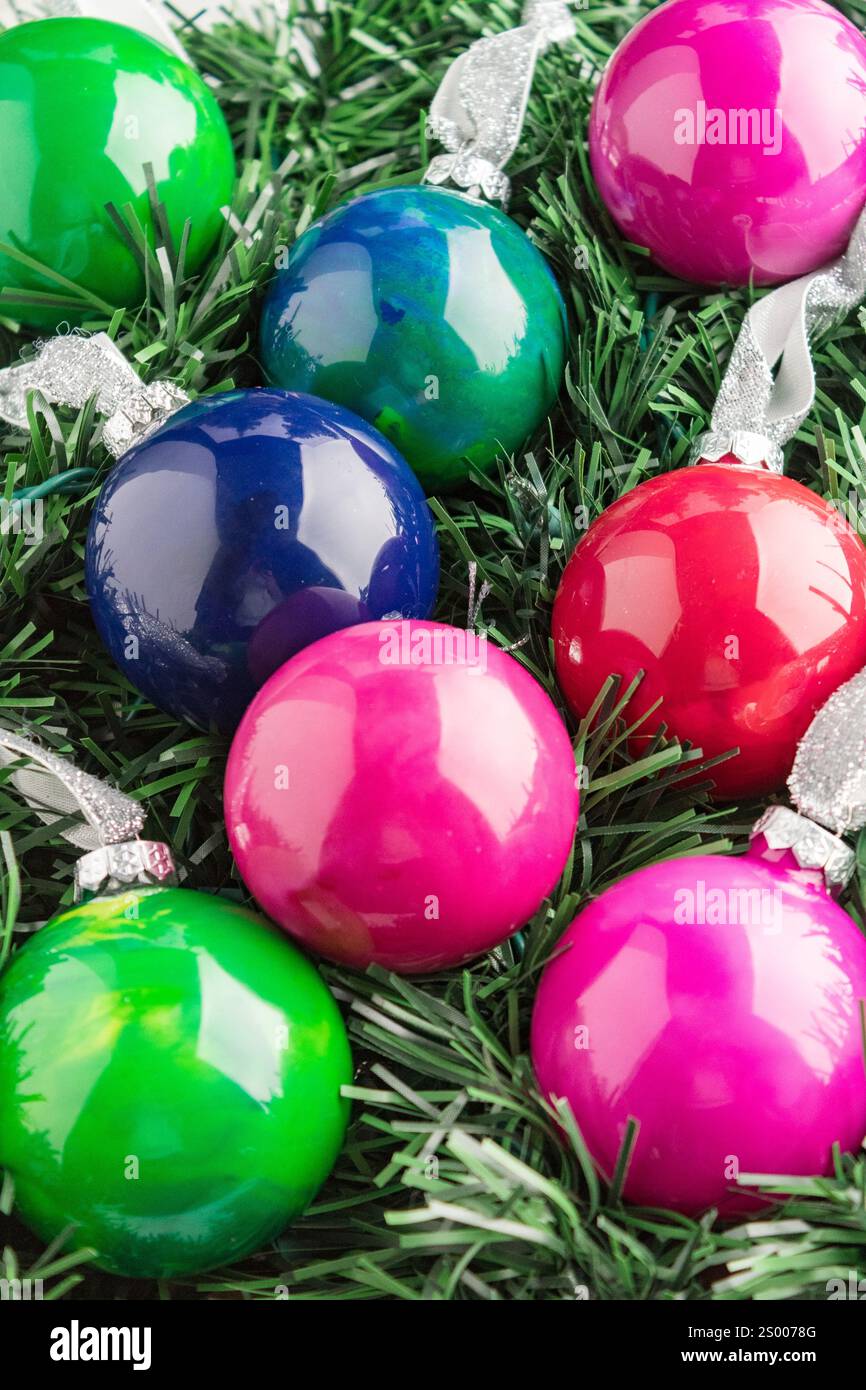 Ornamenti lucidi completati su ghirlanda artificiale verde Foto Stock