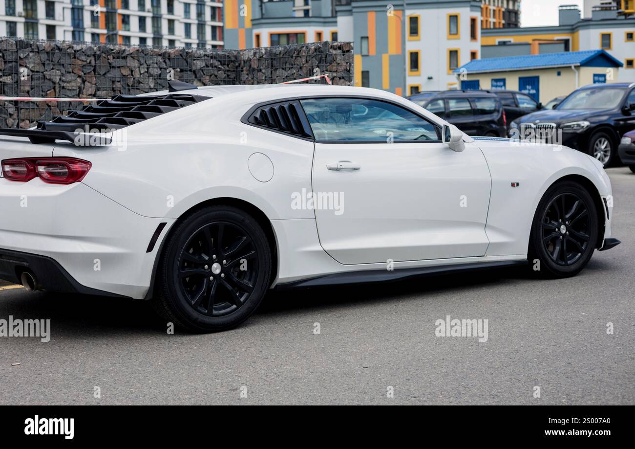 Minsk, Bielorussia, 23 dicembre 2024 - Vista laterale dell'auto bianca potente Chevrolet Camaro parcheggiata in strada. Foto Stock