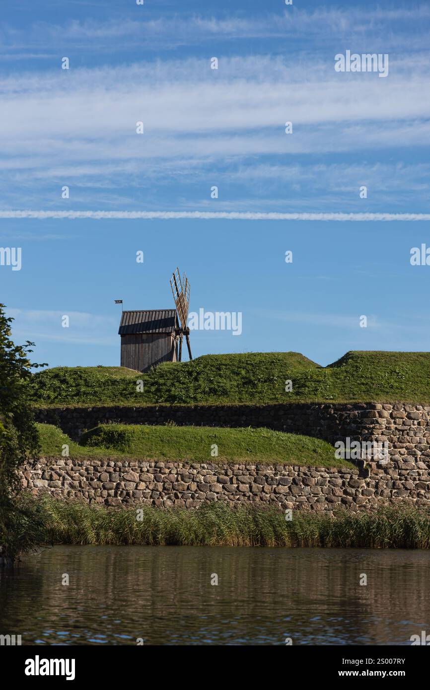 Mulino a vento in legno su un muro di pietra Foto Stock