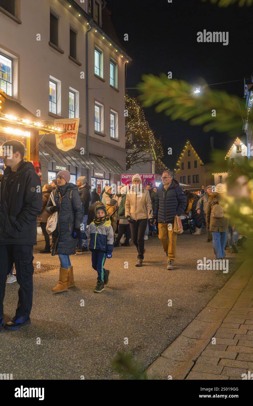 I visitatori passeggiano attraverso il mercatino di Natale illuminato, apprezzano l'atmosfera invernale e le luci festive, la notte delle luci, Nagold, la Foresta Nera e Germa Foto Stock