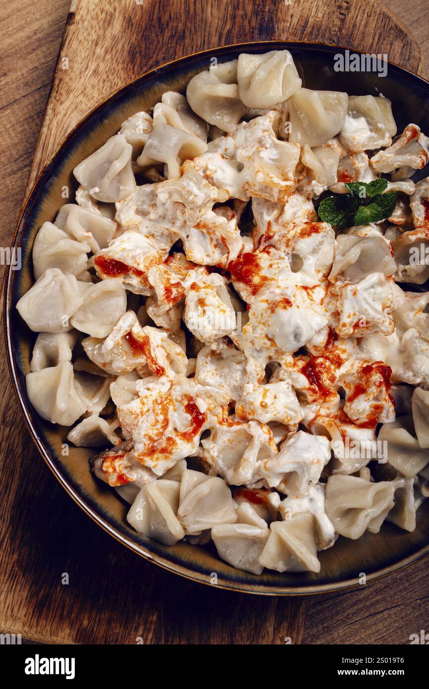 Il piatto è caratterizzato da una generosa porzione di gnocchi turchi conditi con vellutato yogurt e un filo di salsa rossa piccante, . Foto Stock