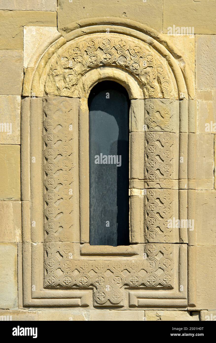 Finestra con cornice ornata presso la cattedrale di Svetitskhoveli, sito patrimonio dell'umanità dell'UNESCO a Mtskheta, Georgia Foto Stock