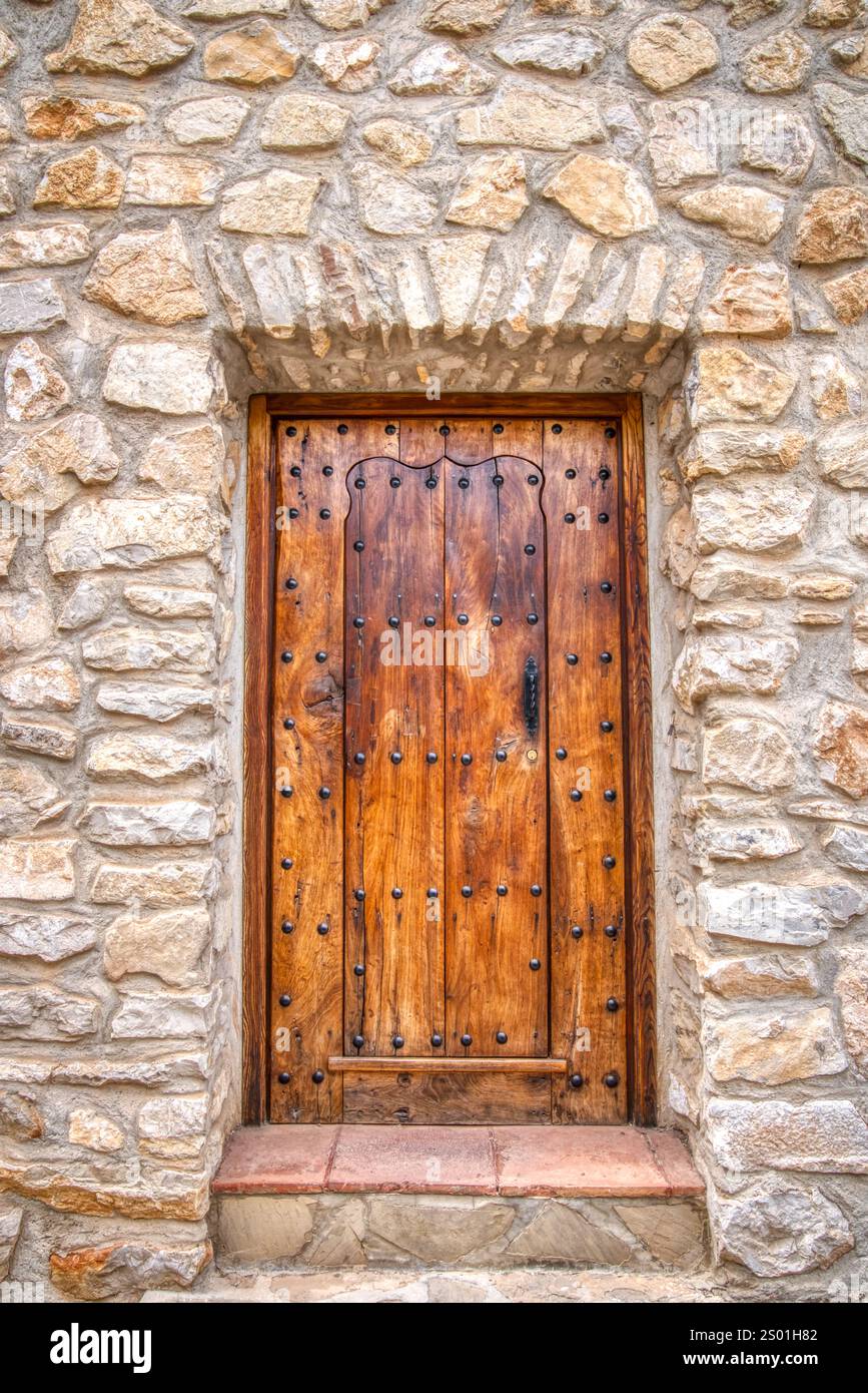 Vecchia porta medievale in legno su un edificio in pietra in Spagna Foto Stock