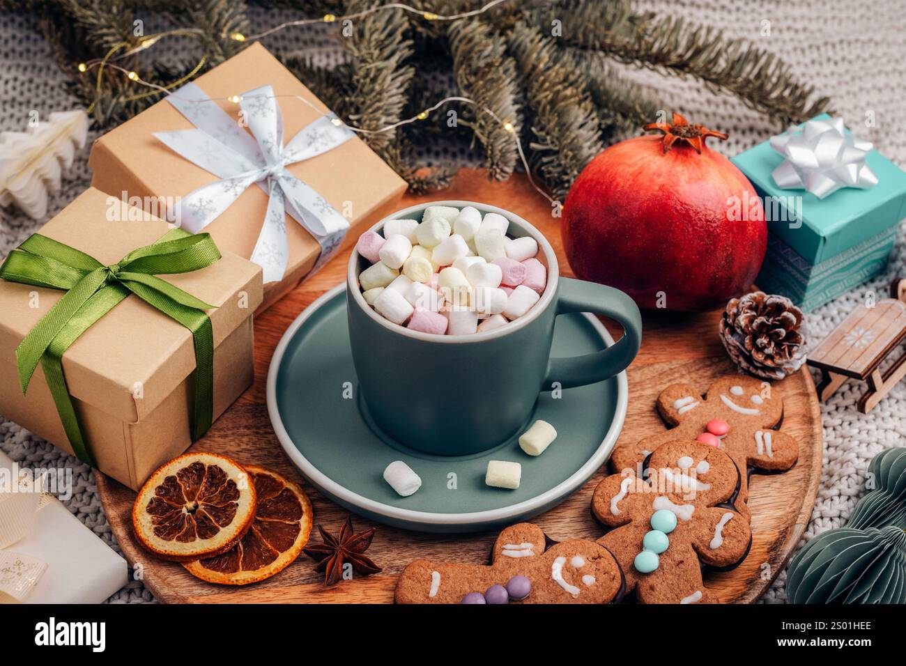 Piatto di cacao caldo con marshmallow circondato da regali di Natale, biscotti allo zenzero e decorazioni natalizie. Vista dall'alto. Foto Stock