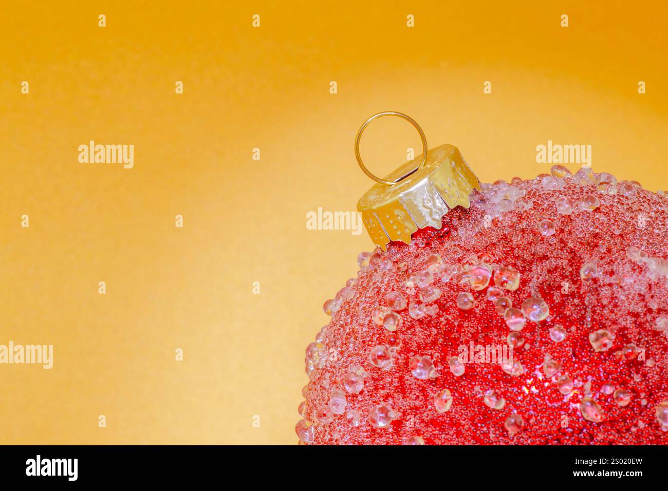 Primo piano della palla rossa dell'albero di Natale sullo sfondo dorato Foto Stock