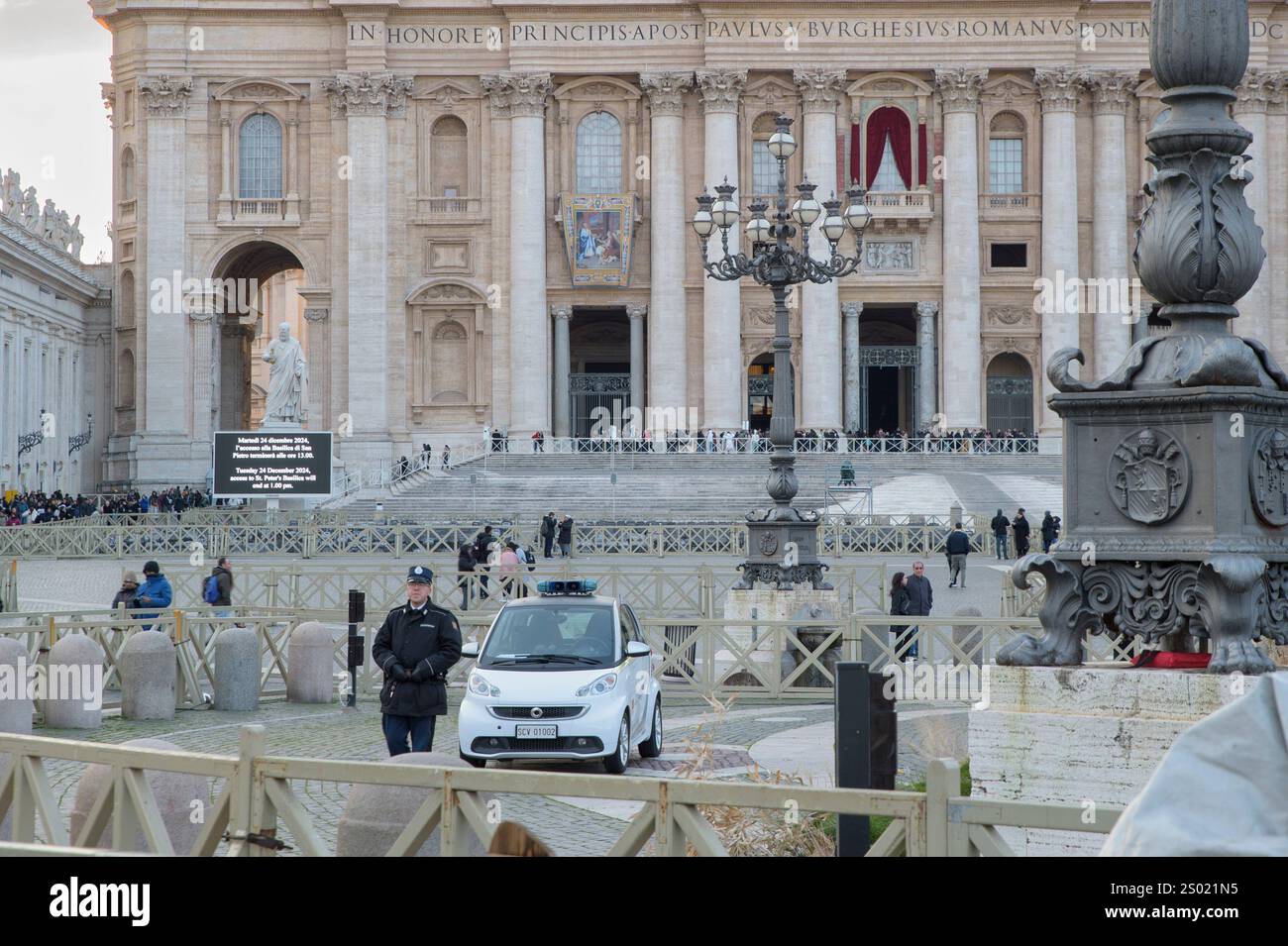Città del Vaticano, Stato del Vaticano. 23 dicembre 2024. Un ufficiale della Gendarmeria Vaticana che custodisce Piazza San Pietro il giorno prima dell'inizio del Giubileo nella città del Vaticano. Nel corso della riunione al Viminale del 17 dicembre 2024 del Comitato Nazionale per l'ordine pubblico e la sicurezza, presieduto dal Ministro dell'interno Matteo Piantedosi, si è deciso di schierare ogni giorno circa 700 agenti aggiuntivi, oltre agli operatori che già prestano servizio quotidiano nella capitale, per rafforzare le attività di sorveglianza e controllo sul territorio, in particolare in Vaticano e in altre strutture sensibili Foto Stock