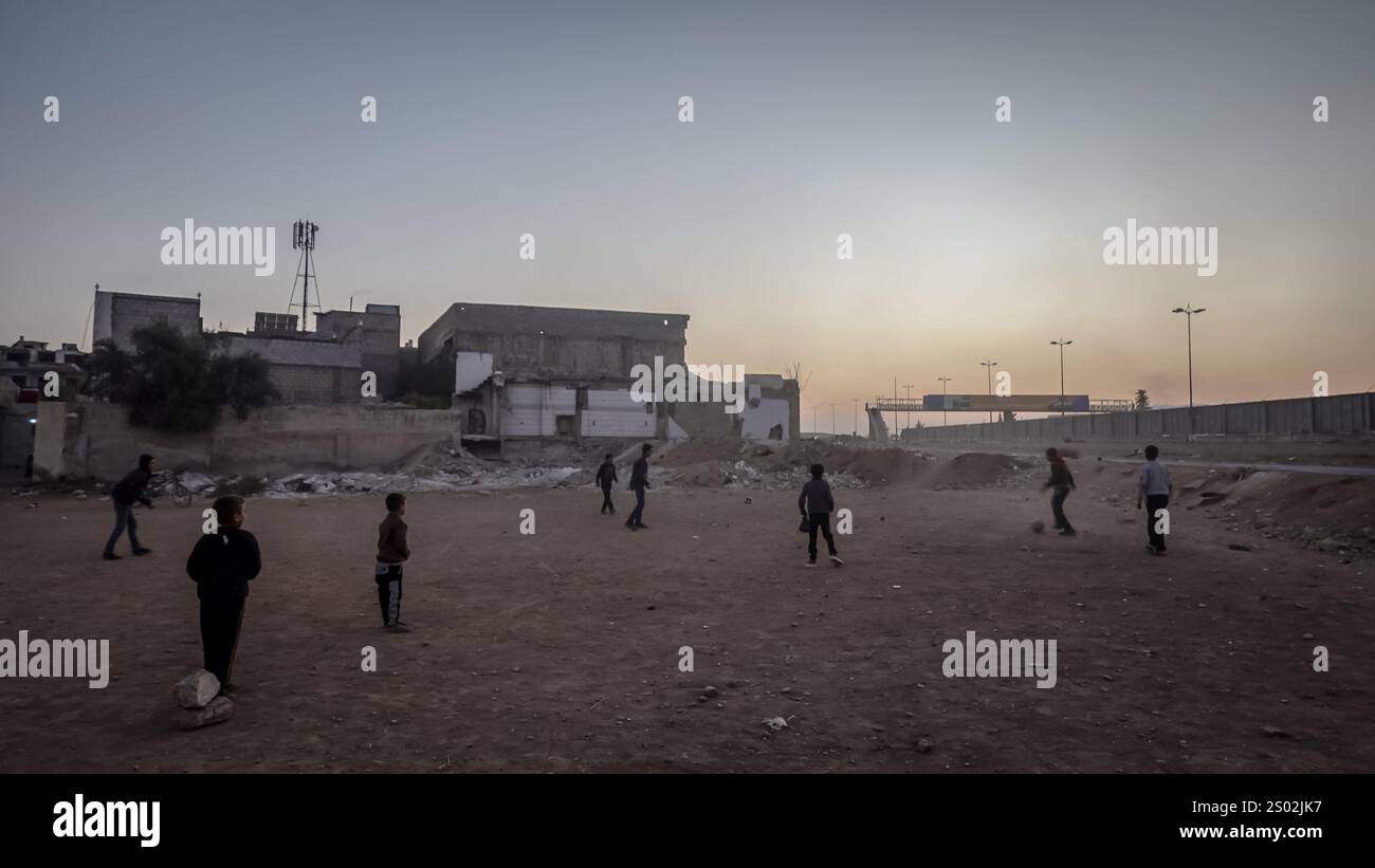 Hama, Siria. 14 dicembre 2024. I bambini giocano a calcio in un quartiere di Ghouta orientale che è ancora in gran parte distrutto a seguito di un assedio di cinque anni da parte dei militari del regime di Assad tra il 2013 e il 2018. Un'offensiva ribelle d'urto portò alla caduta del regime di Bashar al-Assad l'8 dicembre 2024. (Credit Image: © Sally Hayden/SOPA Images via ZUMA Press Wire) SOLO PER USO EDITORIALE! Non per USO commerciale! Foto Stock