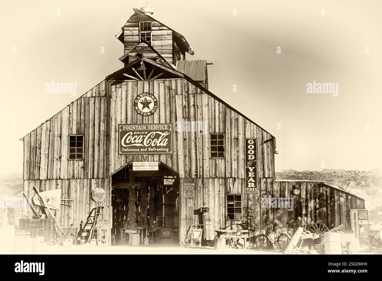 Un grande edificio vecchio stile con un cartello Coca-Cola sul davanti. L'edificio è circondato da un sacco di spazzatura e ha molti oggetti in vecchio stile Foto Stock