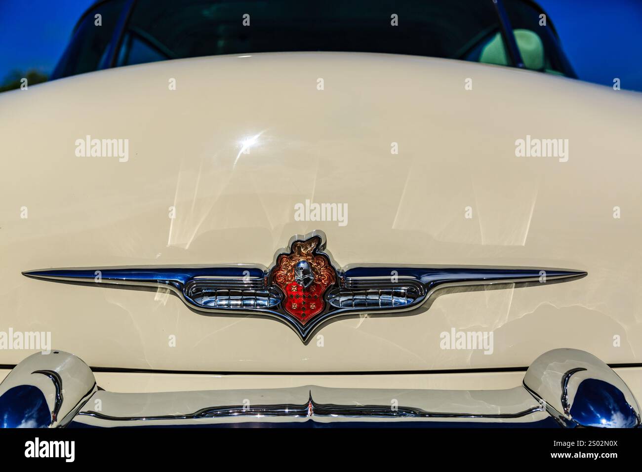 Un'auto d'epoca con un cuore sul cofano. Il cuore è rosso e bianco. L'auto è bianca e ha una finitura lucida Foto Stock