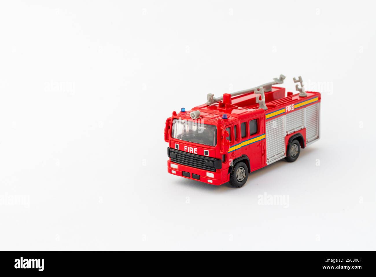 Modello di giocattolo rosso dei vigili del fuoco su sfondo bianco con spazio per il testo. Foto Stock