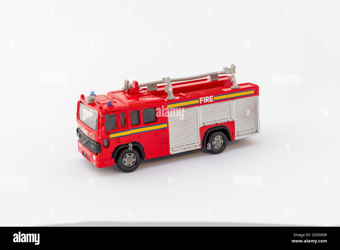 Vista laterale di un motopompa antincendio in miniatura su sfondo bianco con spazio di copia Foto Stock
