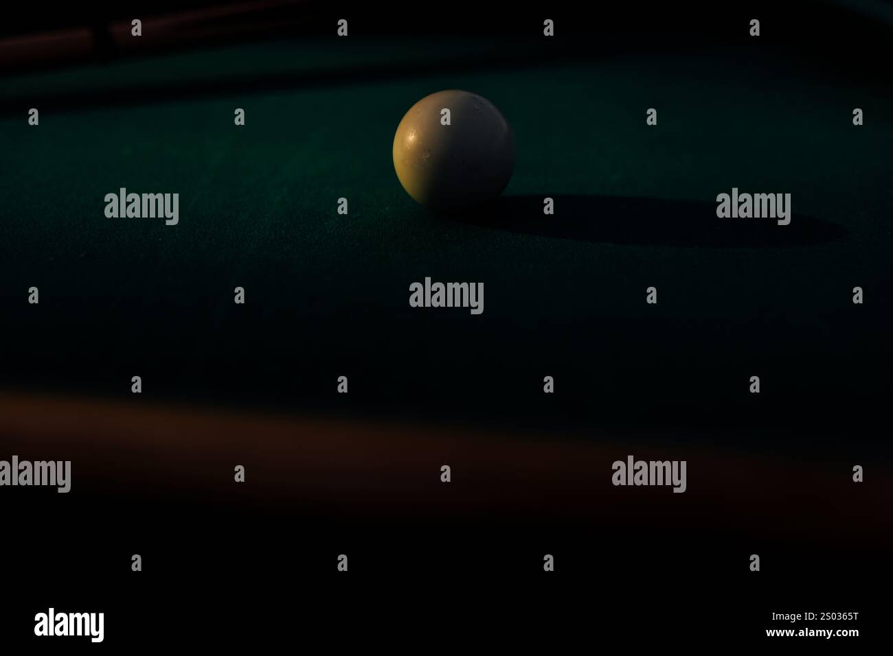 Un tavolo da biliardo con palle da biliardo sparse, un bastoncino e accessori catturati in una scena dinamica e pronta per il gioco. L'attenzione dettagliata sull'apparecchiatura Foto Stock
