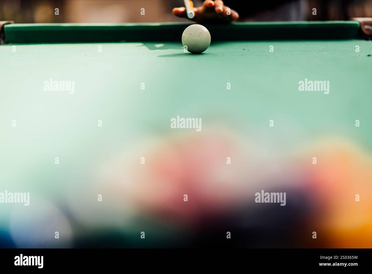 Un tavolo da biliardo con palle da biliardo sparse, un bastoncino e accessori catturati in una scena dinamica e pronta per il gioco. L'attenzione dettagliata sull'apparecchiatura Foto Stock