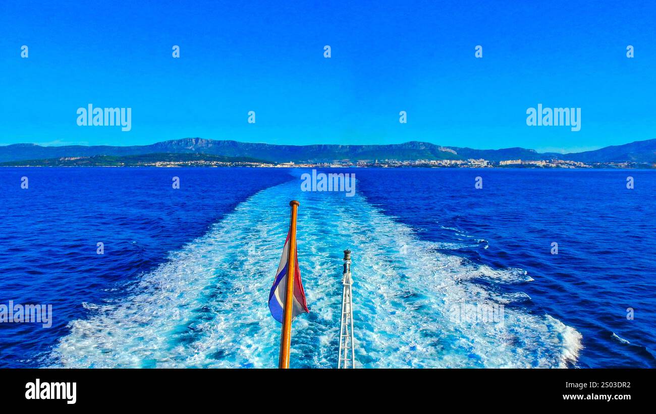 Bandiera croata che sventola sull'albero della nave, onde agitate dalle eliche di un grande motoscafo, vista della poppa della nave Foto Stock