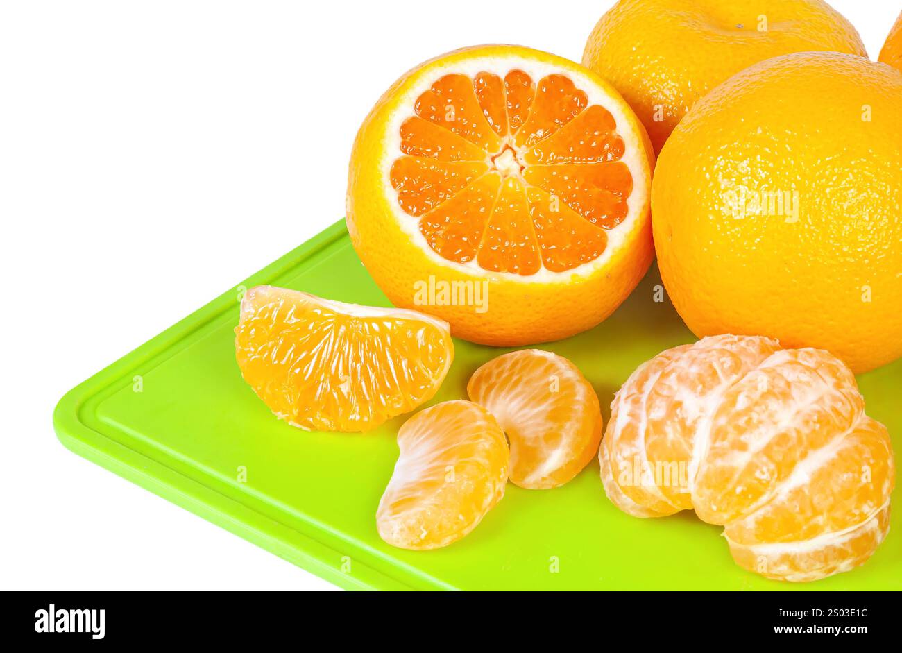 Le arance luminose sono visualizzate su un tagliere verde, mostrando pezzi interi, tagliati a fette e segmentati pronti per l'uso in ricette o spuntini. Foto Stock