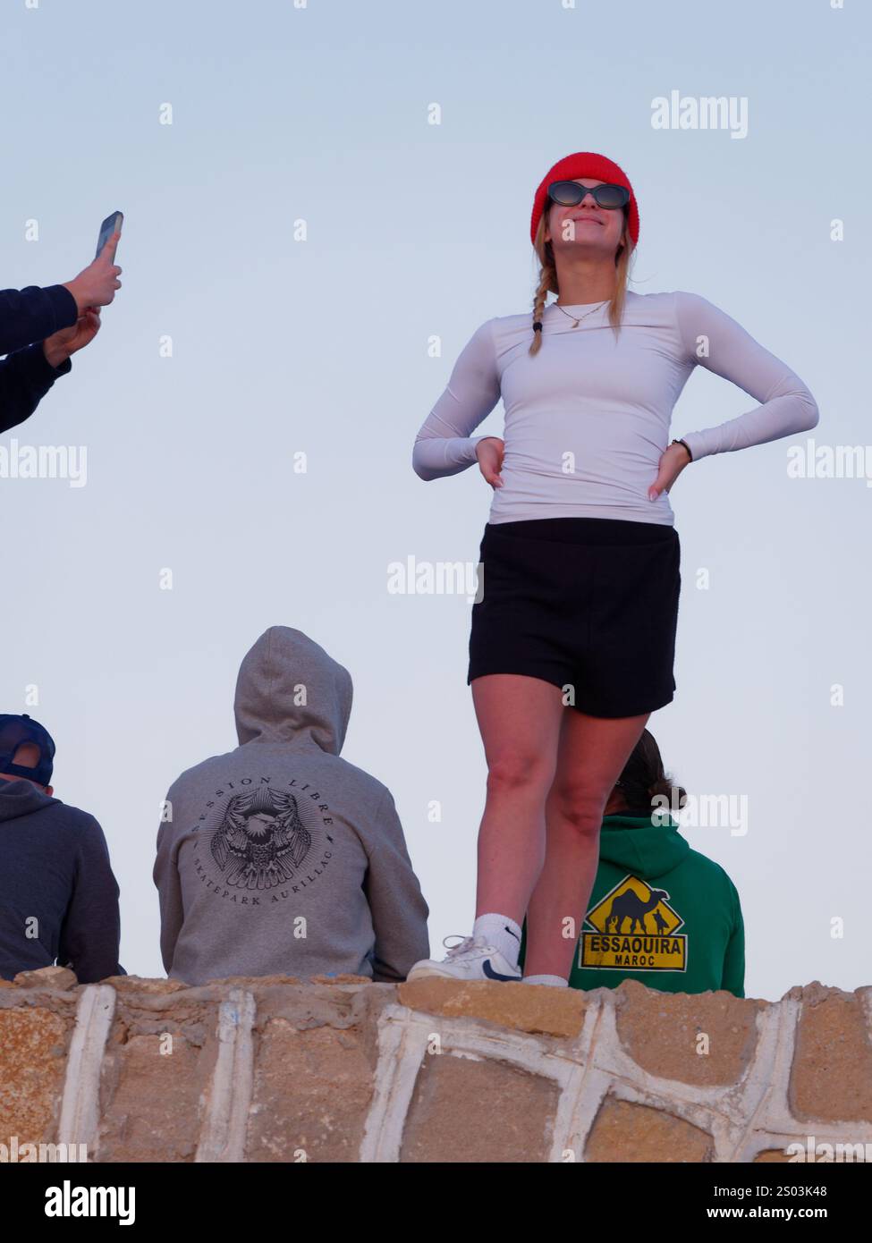 Amici che scattano foto tra loro con gli spettatori allo Skate Park dietro il villaggio di Taghazout, in Marocco. 23 dicembre 2024 Foto Stock