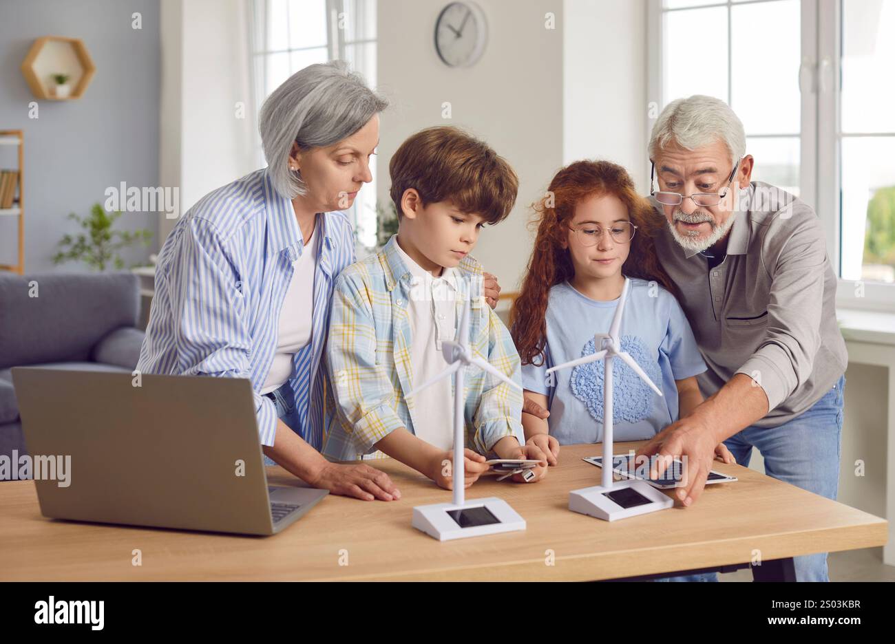 Nonni che mostrano ai bambini un modello di turbina eolica, da vicino Foto Stock
