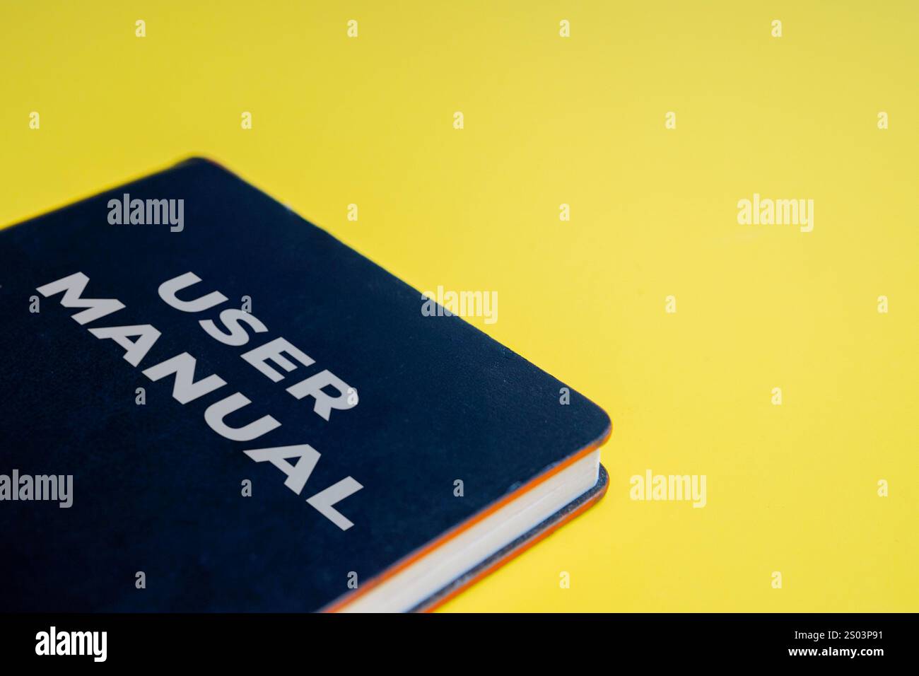 Immagine ravvicinata di un manuale dell'utente su uno sfondo giallo chiaro. Guida, supporto, concetto di tutorial. Foto Stock