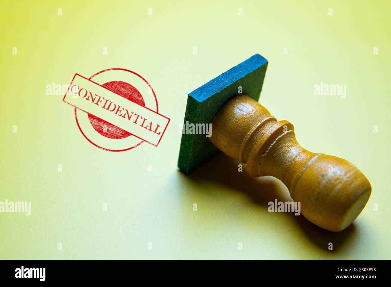 Immagine ravvicinata di un timbro rosso "RISERVATO" su sfondo giallo, con un timbro di legno. Foto Stock