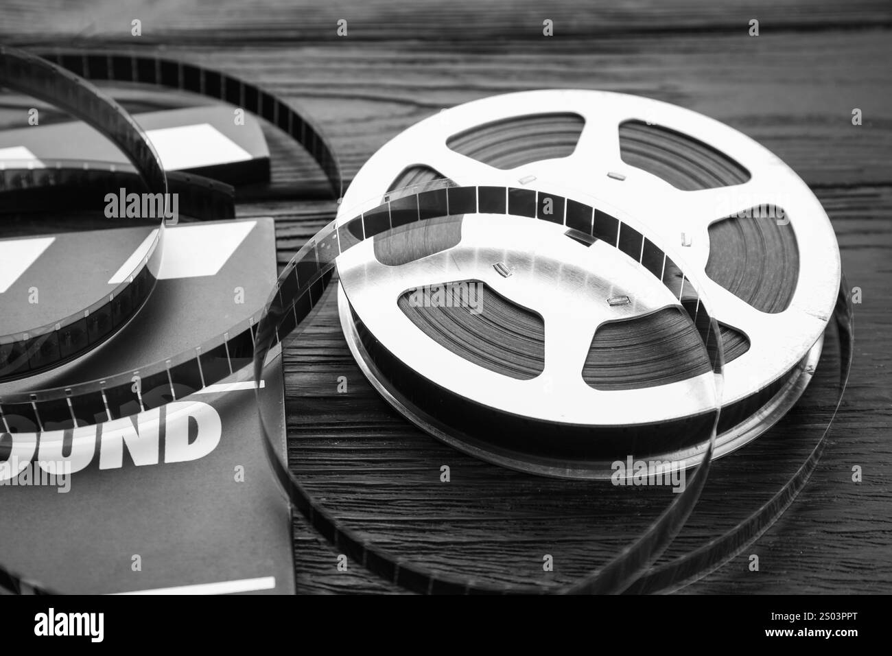 Clapper cinematografico e film su tavolo in legno nero, primo piano Foto Stock