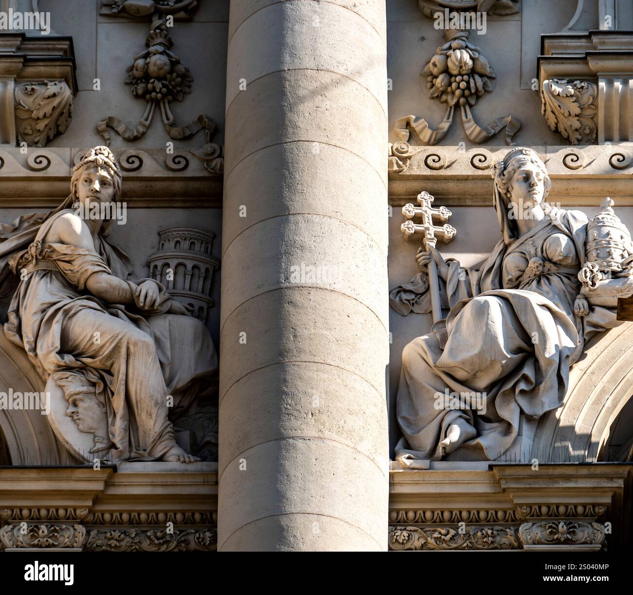 Due sculture classiche su una facciata dell'edificio, raffiguranti figure femminili. Una figura contiene una corona e una croce, mentre l'altra appare contemplativa, Foto Stock