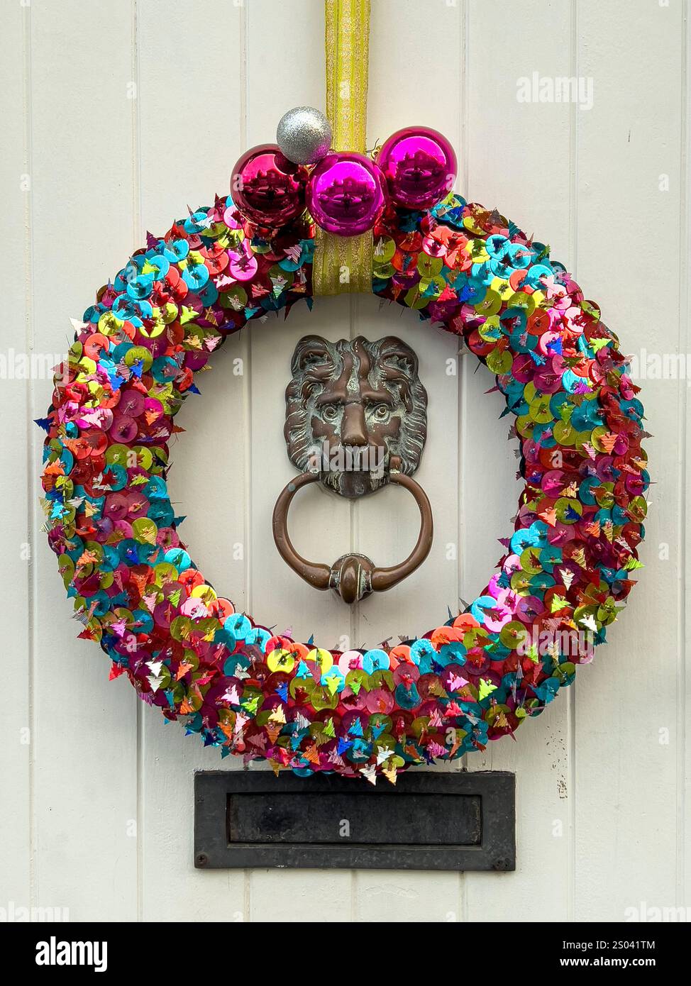 Una colorata corona di Natale fatta in casa appesa su una porta d'ingresso (Regno Unito) Foto Stock