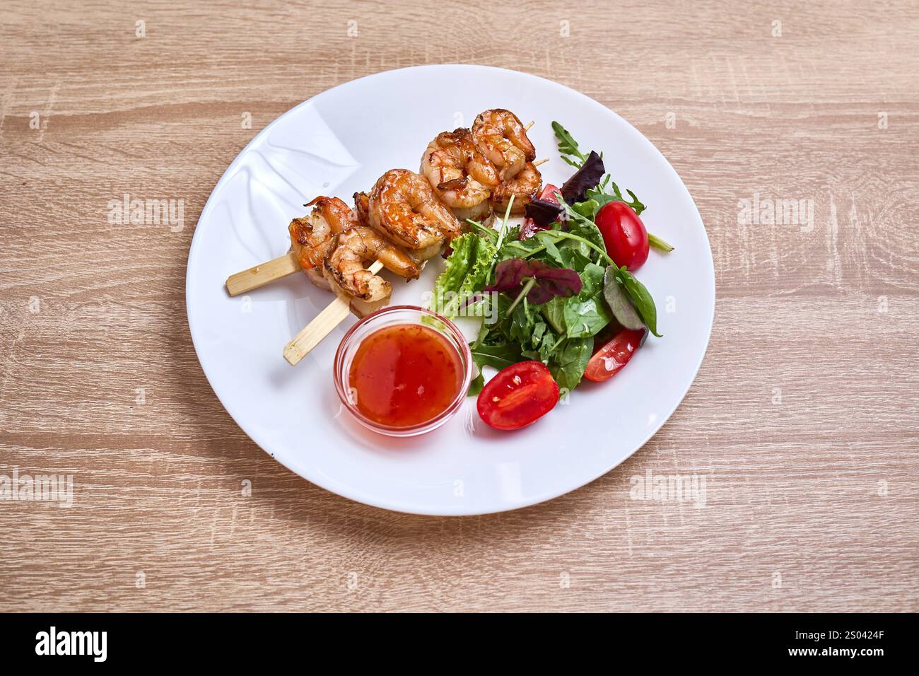 Spiedini di gamberi grigliati serviti con insalata fresca e salsa al peperoncino dolce. Foto Stock