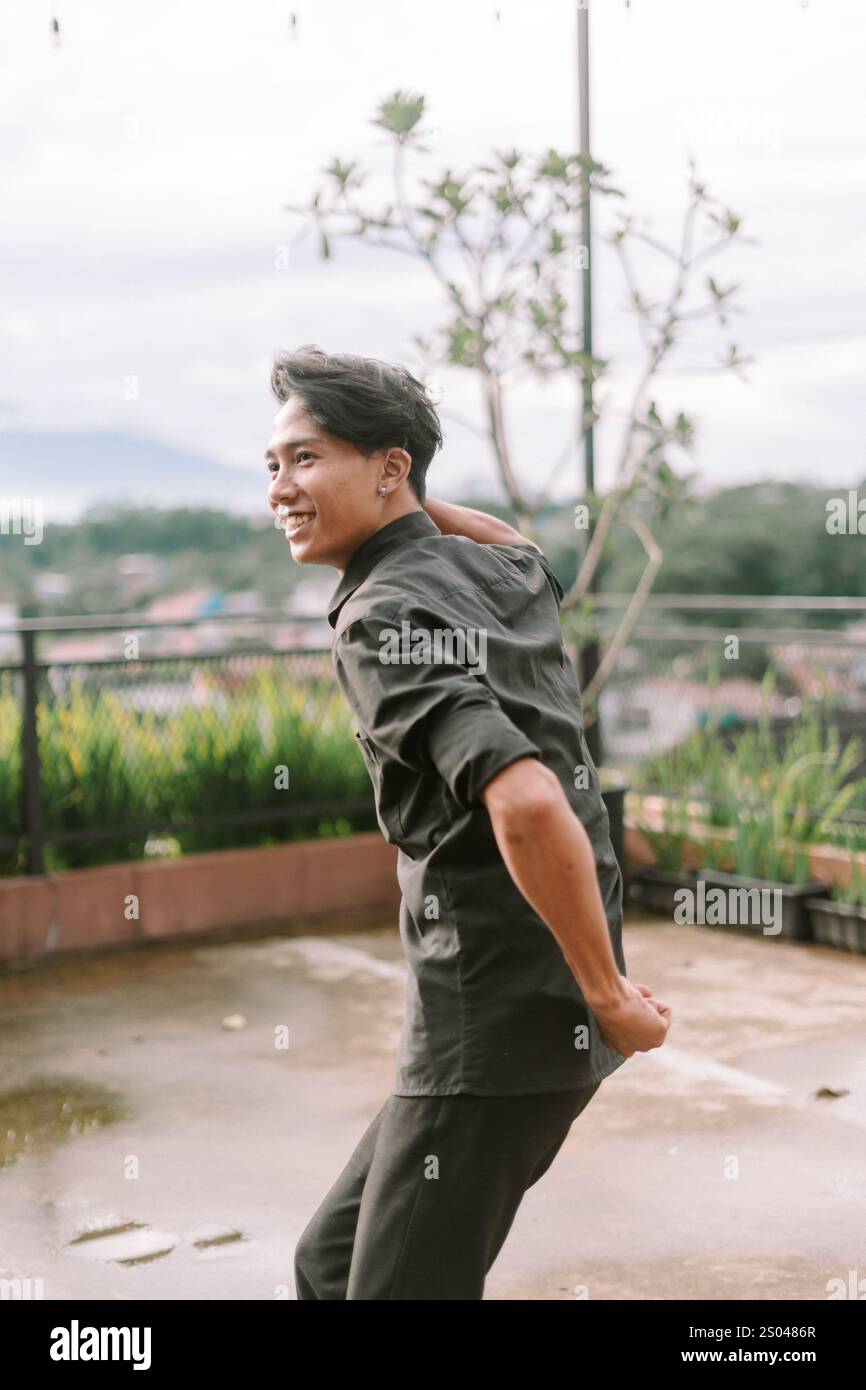 Uomo del sud-est asiatico che si allena all'aperto e si impegna in una routine di fitness. Stile di vita attivo, vita sana e concetto di attività fisica. Luce naturale Foto Stock