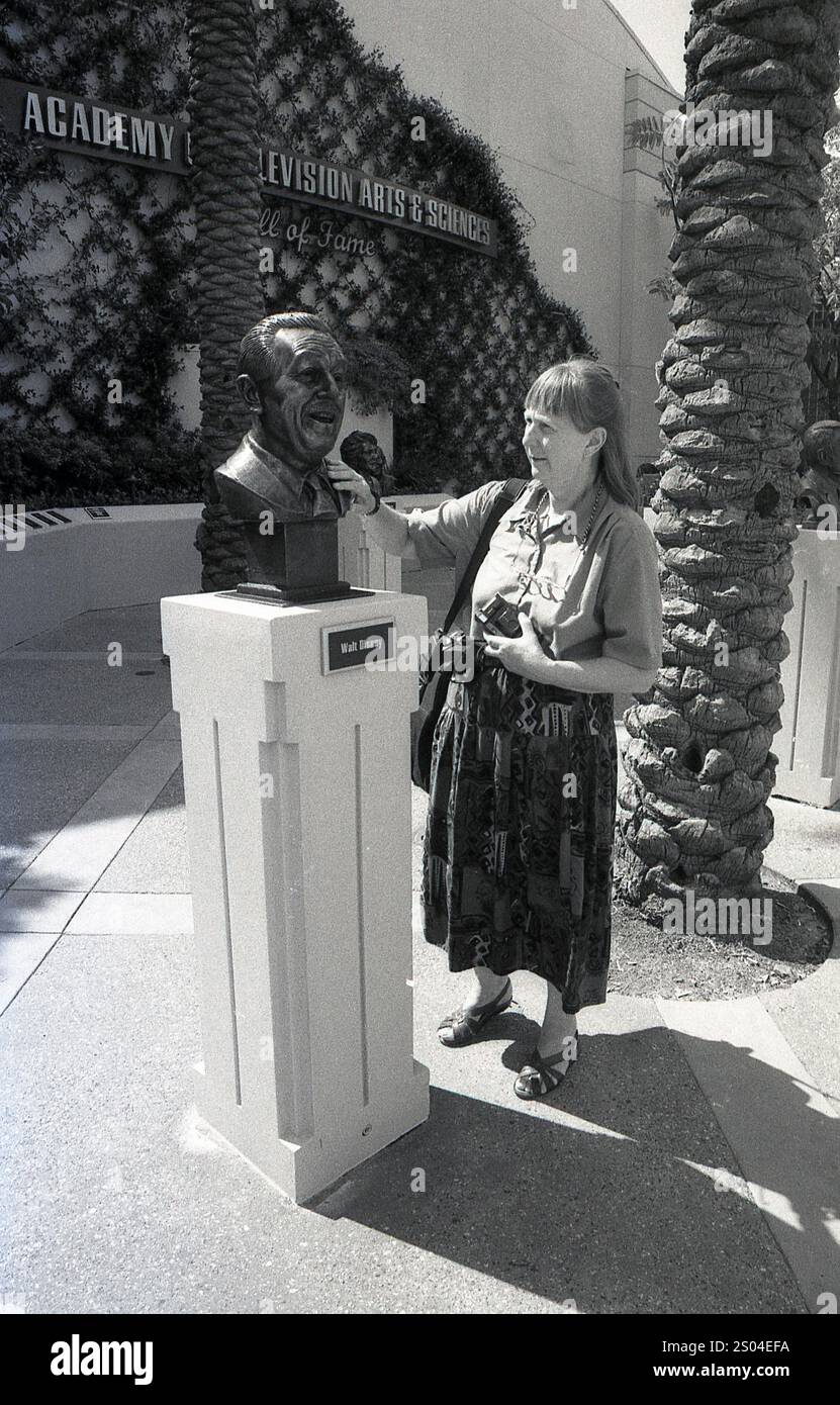 Anni '1990, una donna turistica che tocca il busto di Walt Disney all'Academy of Television, Arts & Science Hall of Fame a Daytona Beach, USA. Foto Stock