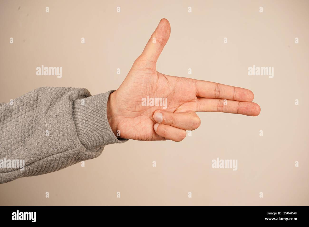 La mano che punta come una pistola. Indicizza e medio dita rivolte verso l'esterno e le due dita inferiori sono piegate nel palmo. Pollice in mano Foto Stock
