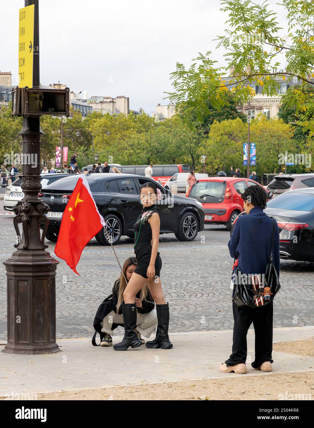 Tre donne con bandiera della Repubblica Popolare Cinese in servizio fotografico a Parigi , Francia Foto Stock