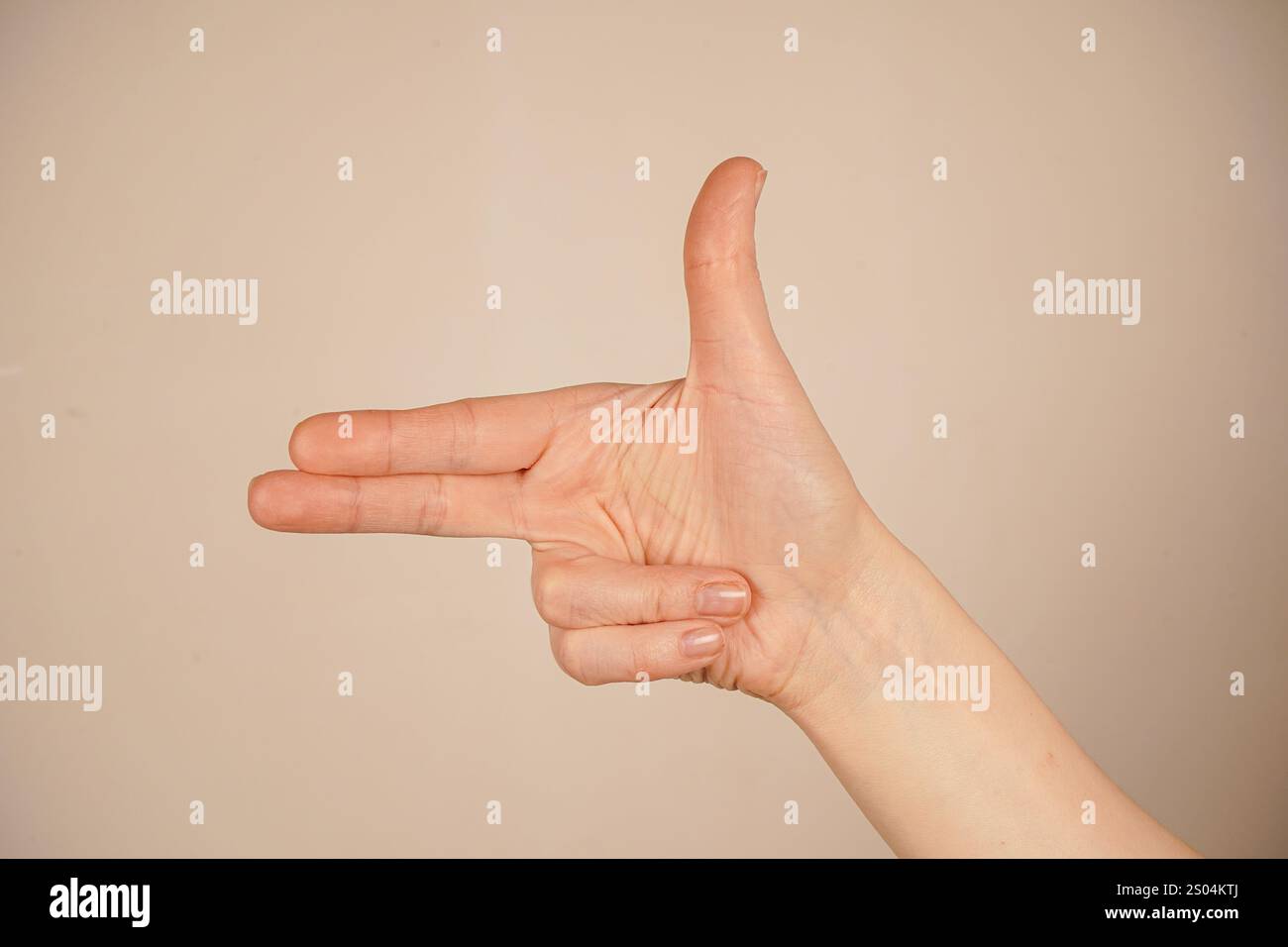 Indicizza e medio dita rivolte verso l'esterno e le due dita inferiori sono piegate nel palmo. Pollice in mano. La mano che punta come una pistola Foto Stock