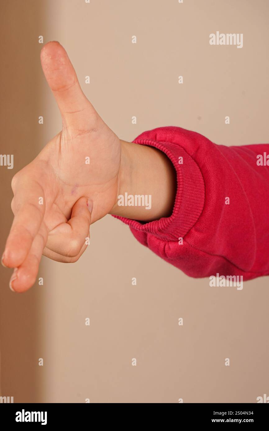 Indicizza e medio dita rivolte verso l'esterno e le due dita inferiori sono piegate nel palmo. Pollice in mano. La mano che punta come una pistola Foto Stock